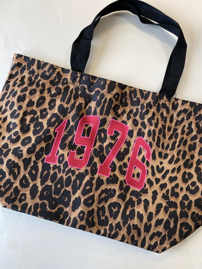 Leopard print bag with '1976' in pink on a white background
