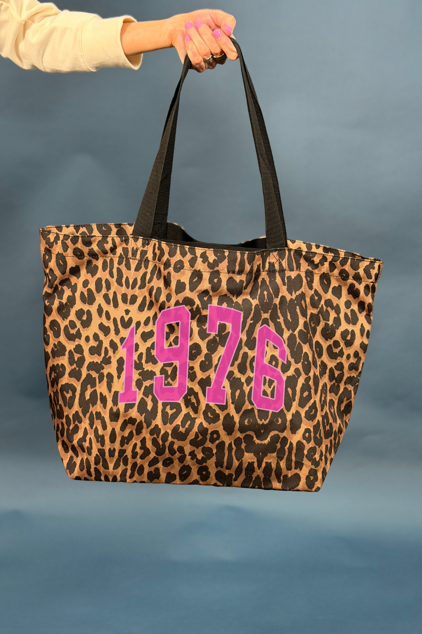 Leopard print tote bag with '1976' in pink on a blue background