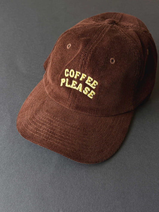 Brown cap with 'Coffee Please' text on a grey background