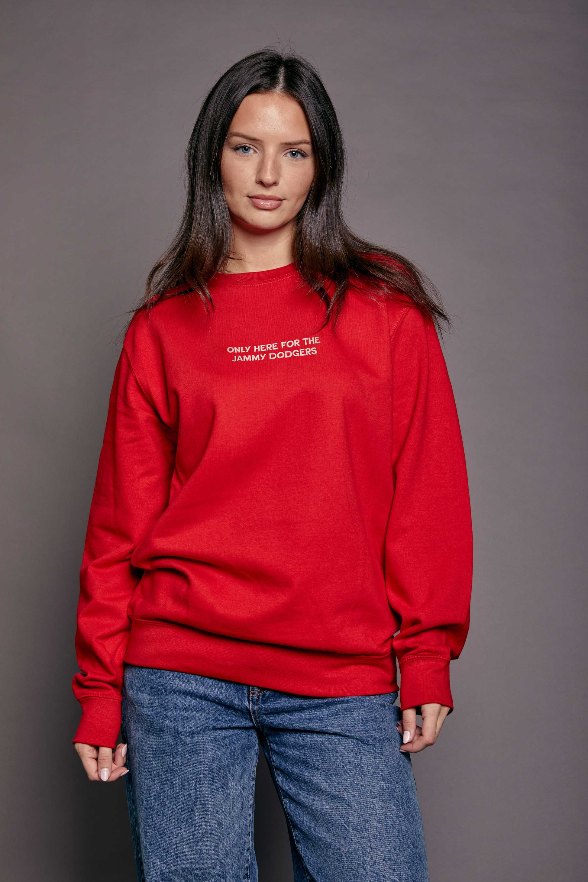 Person wearing a red sweatshirt with text 'only here for the jammy dodgers' on a grey background