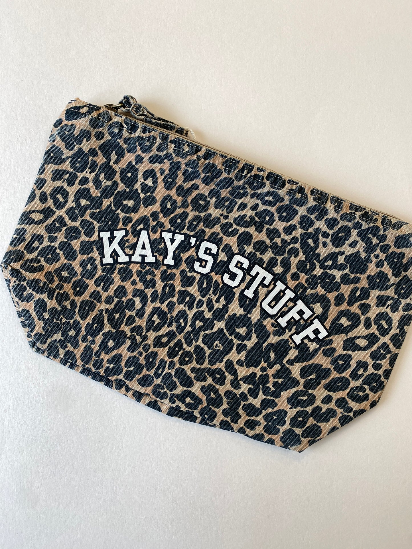 Leopard print pouch with 'KAY'S STUFF' text on a light background
