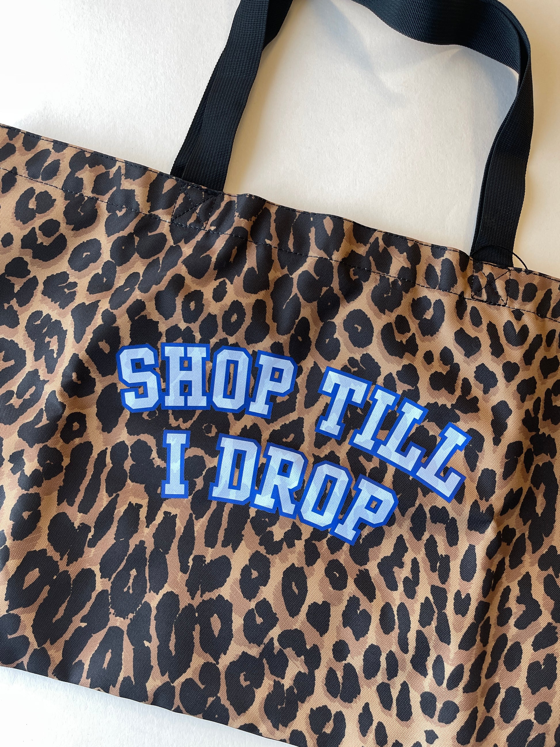 Leopard print shopping bag with 'SHOP TILL I DROP' text in blue
