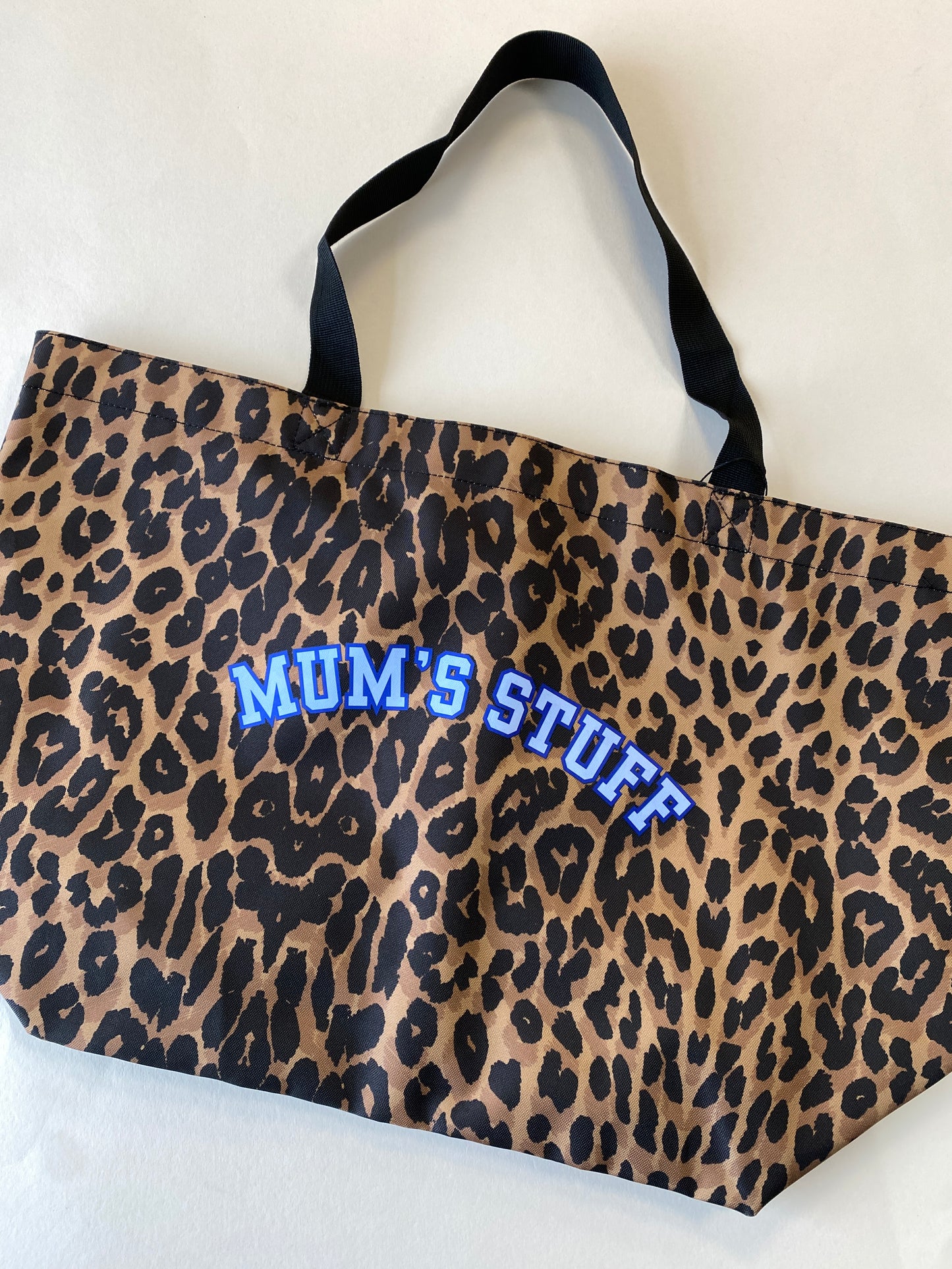 Leopard print bag with 'MUM'S STUFF' text in blue on a white background