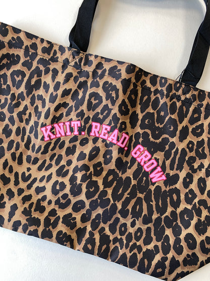 Leopard print tote bag with slogan 'Knit. Read. Grow' text in pink