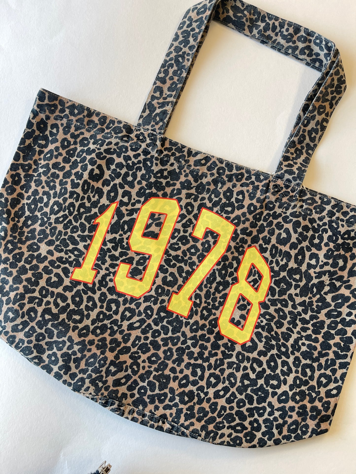 Leopard print bag with '1978' text on a white background