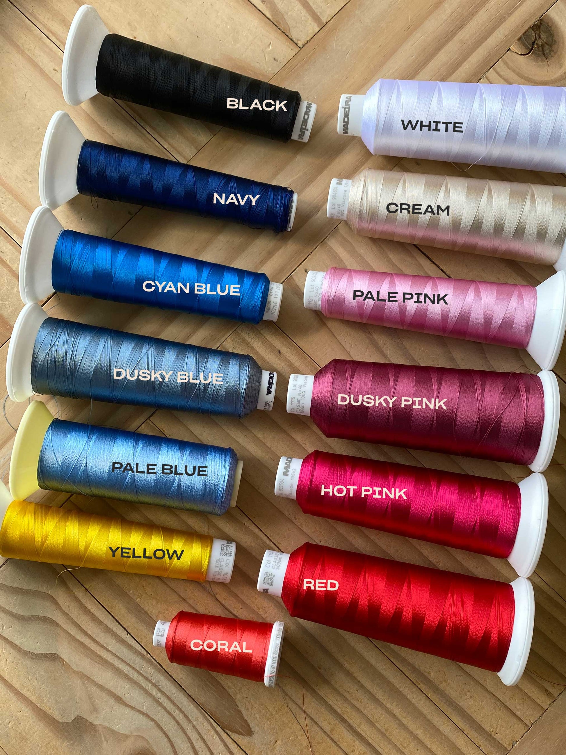 Spools of thread in various colors on a wooden surface