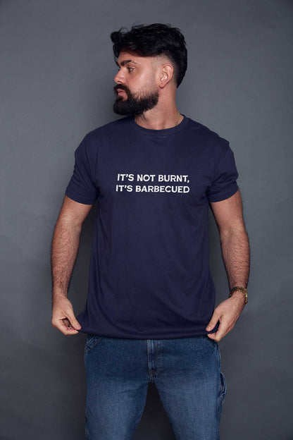 Man wearing a navy blue t-shirt with slogan 'it's not burnt, it's barbecued' on a grey background
