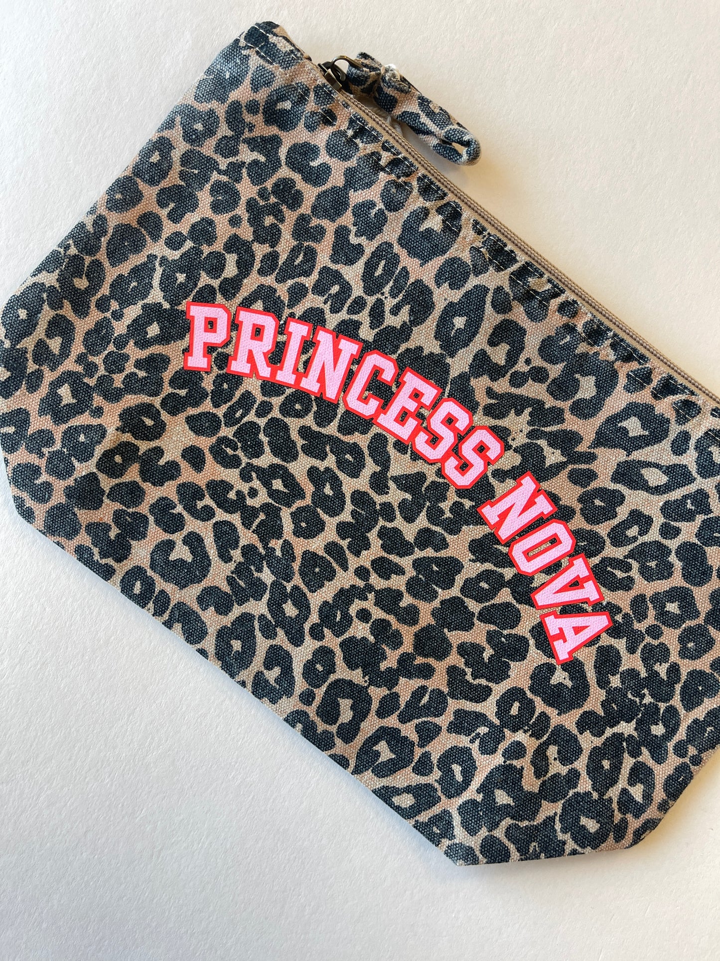 Leopard print zip pouch bag with 'Princess Nova' text in pink and red on a light background