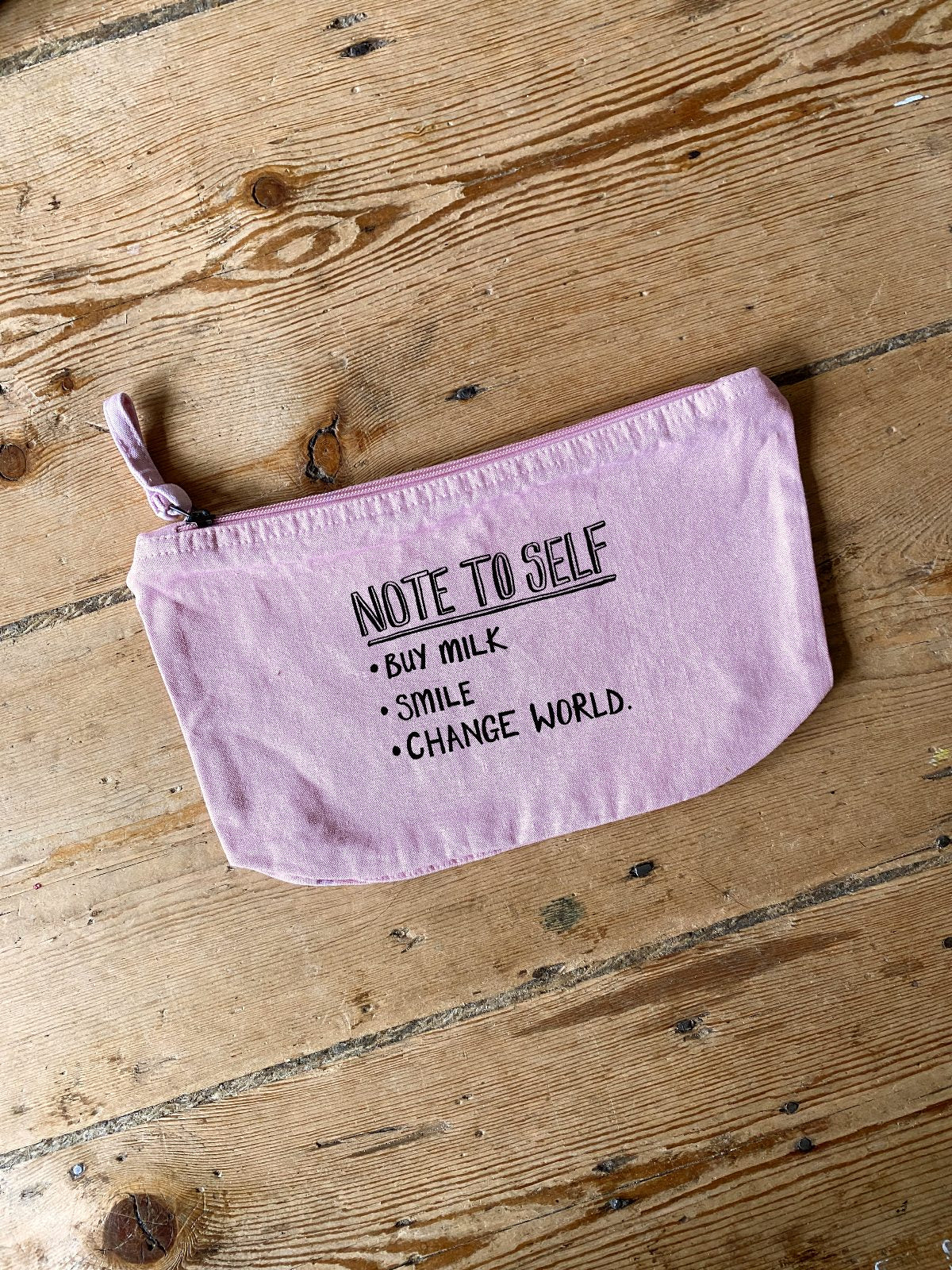 Pink pouch with Note to self Slogan text on a wooden surface