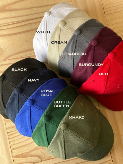 Collection of baseball caps in various colors on a wooden surface