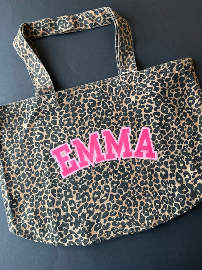 Leopard print bag with 'EMMA' in pink on a dark background