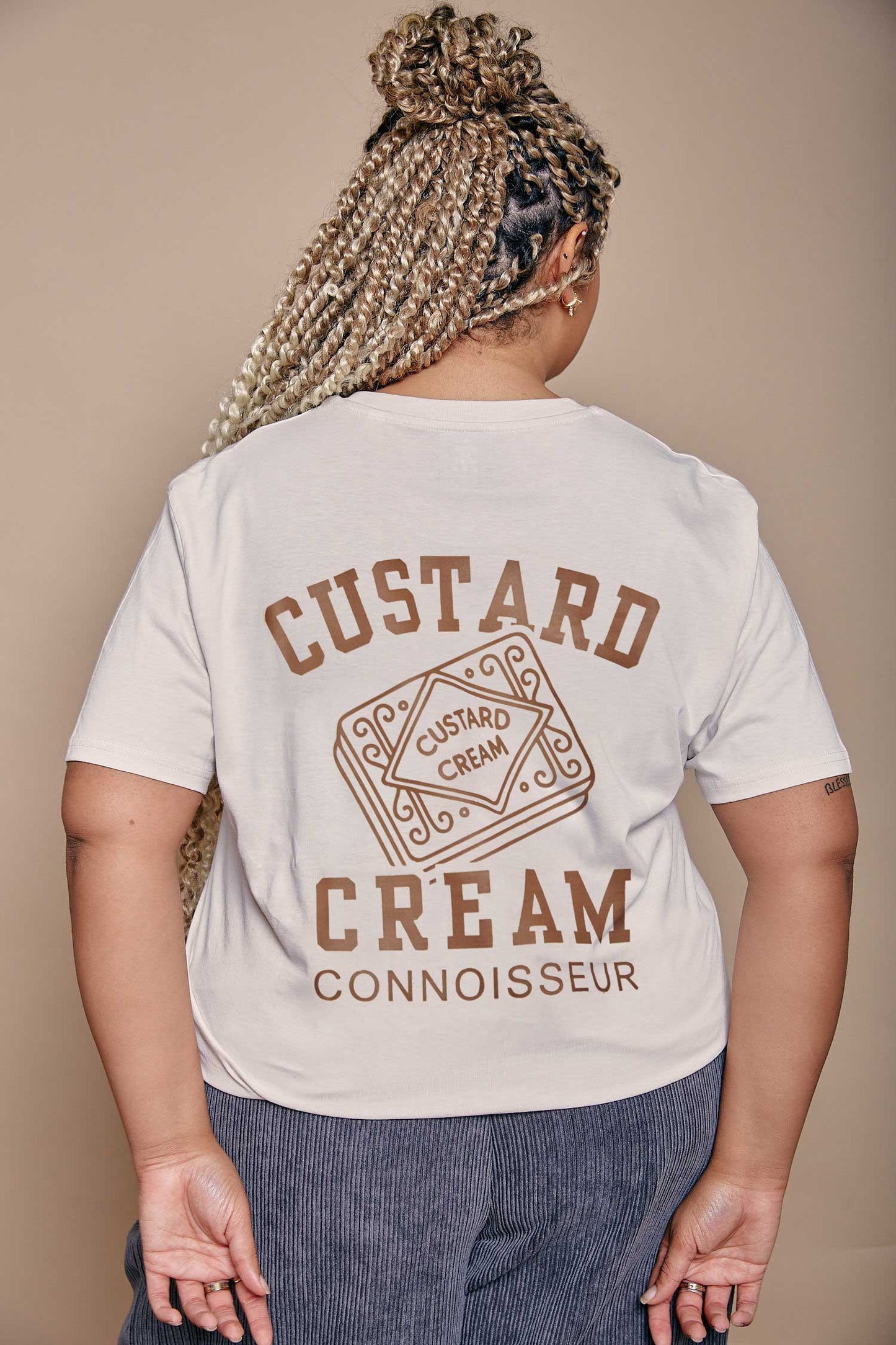 Person wearing a t-shirt with 'Custard Cream Connoisseur' text and graphics on the back.