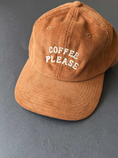 Brown cap with 'Coffee Please' text on a grey background